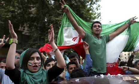 Iranian football fans - brandishing national flags - at a Tehran street celebration