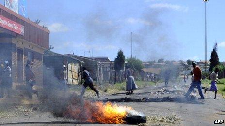 Protesters run away from South African police who fire rubber bullets at them on 16 February 2011, in Wesselton township outside of Ermelo