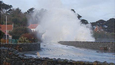 Waves crash over the sea wall at Perelle