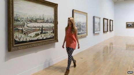 A museum employee walks past English artist Laurence Stephen Lowry"s painting "The Pond 1950" at the Lowry and the Painting of Modern Life exhibition at Tate Britain in London on June 24, 2013