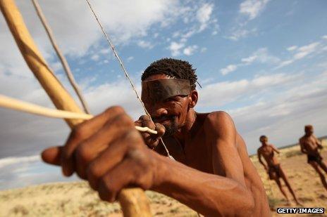 A hunter gatherer aims his bow and arrow