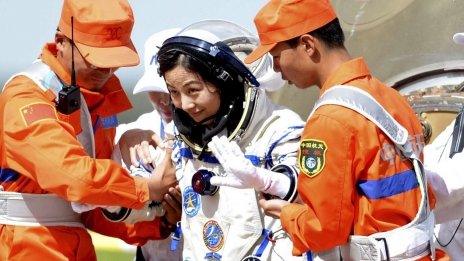 Chinese astronaut Wang Yaping, centre, goes out of the re-entry capsule of China's Shenzhou 10 spacecraft after its successful landing in Siziwang Banner, north China's Inner Mongolia Autonomous Region on 26 June 2013