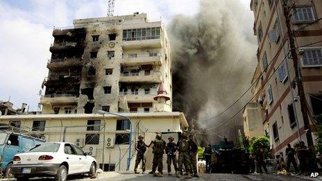 Lebanese soldiers stand by as black smoke rises from a mosque in Sidon where Sunni cleric Sheik Ahmad al-Assir preaches