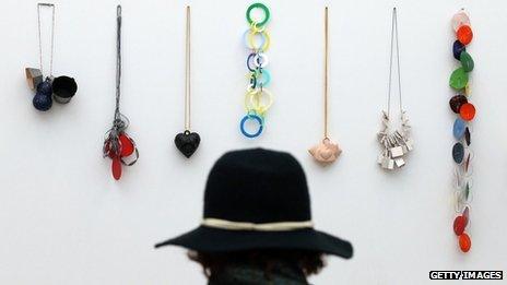 A visitor looks at jewellery on display at the Collect art fair at Saatchi Gallery on May 9, 2013 in London, England