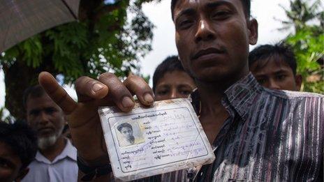 A Rohingya in Ah Nauk Pyin holds up his white ID card