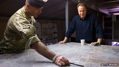 David Cameron being shown a map by a soldier