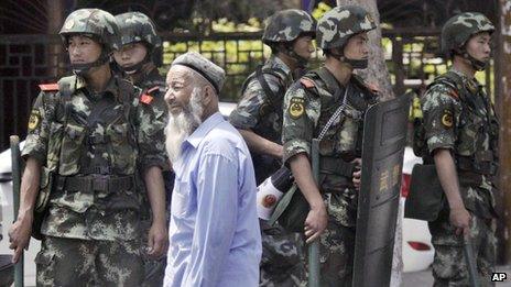 Armed police officers stand guard near the Erdaoqiao Bazaar in Urumqi (June 29, 2013)