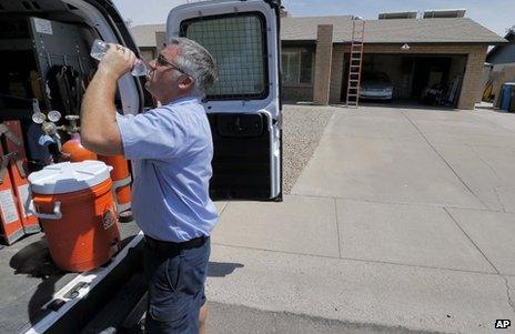 Air conditioning technician Michael Hawks cools off after inspecting a unit in Phoenix, Arizona, on Friday