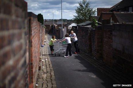 Kids play with shopping trolley in backyard