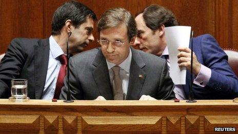 Paulo Portas (R) talks to ex-Finance Minister Vitor Gaspar (L) behind Prime Minister Pedro Passos Coelho June 25, 2012