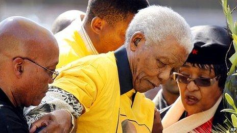 Former South African President Nelson Mandela (centre) is helped as he walks up the stairs by then-current ANC president and presidential candidate Jacob Zuma (left), his former wife Winnie (right) and his grandson Mandla (behind) at the start of an ANC rally in Johannesburg, South Africa [19 April 2009]