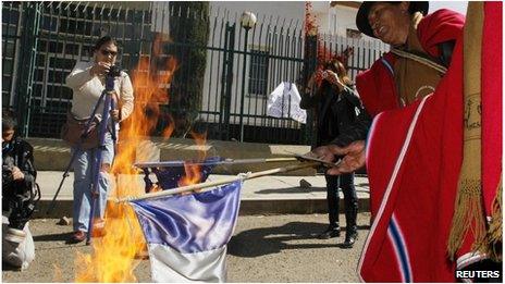 Bolivian protester burning French flag in La Paz