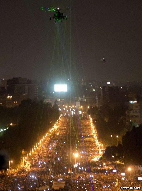 Helicopter flying above Cairo, picked out by laser pens