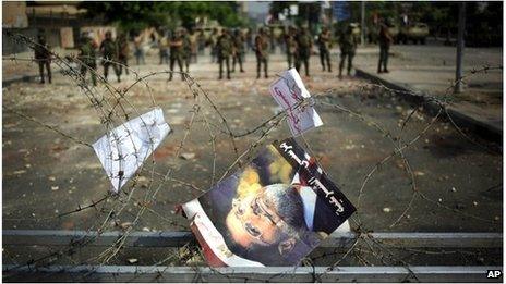 Morsi poster in barbed wire barricade at Republican Guard barracks in Cairo (9 July 2013)