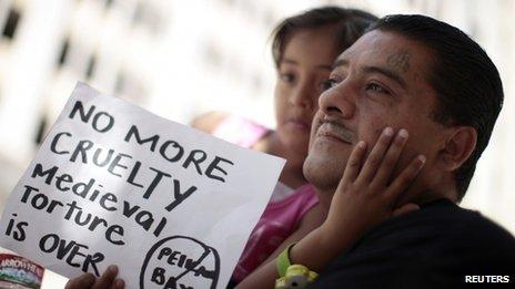 Ever, 40, holds his daughter Darlyne, 5, at a rally in Los Angeles, California 1 August 2011