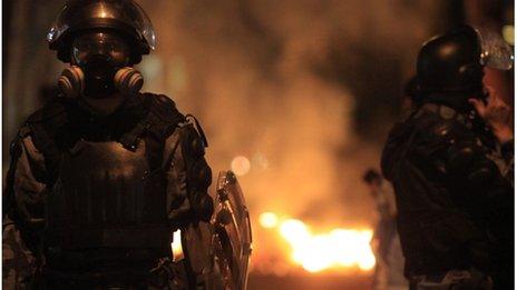 Riot police stand next to a fire after clashing with demonstrator in front of Rio de Janeiro Government Guanabara Palace, 11 July