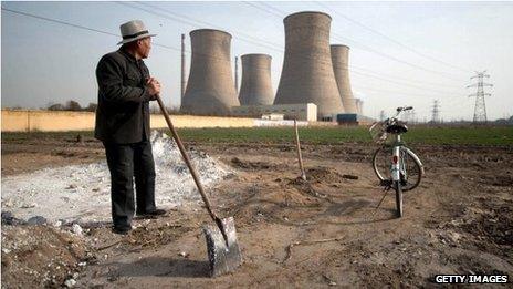 Man looking towards power station chimney stacks in Zingtai