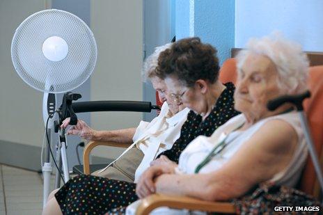 Old women sitting in front of fan