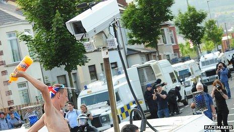 Man prepares to hit police vehicle with 2 litre bottle of soft drink