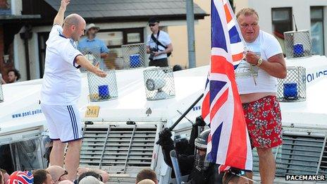 Men stand on police landrover