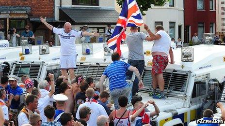 Men stand on police landrover