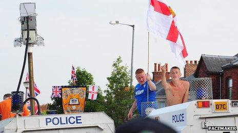 Men plant flag on police vehicle