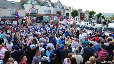 Crowd blocked by police vehicles