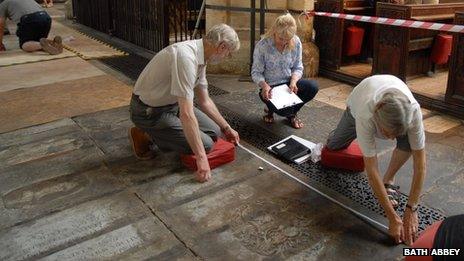 Volunteers carry out a ledger stone recording at Bath Abbey