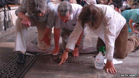 Volunteers carry out a ledger stone recording at Bath Abbey