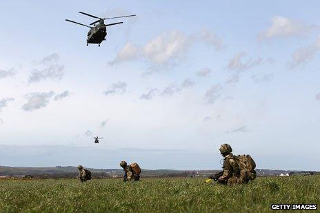 Helicopter flies above troops