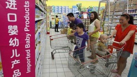 A family looks at imported milk powder products at a supermarket in Beijing, 3 July 2013