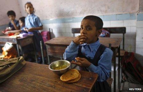 A schoolgirl eats her free mid-day meal, distributed by a government-run primary school, in New Delhi May 8, 2013