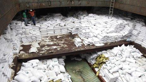 Panamanian workers stand atop sacks of sugar inside a container of a North Korean-flagged ship at the Manzanillo International container terminal, 16 July