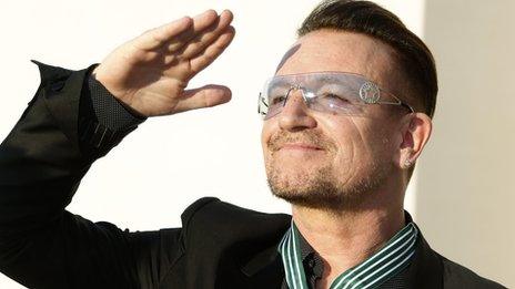 Bono reacts after being awarded as Commander in the Order of Arts and Letters by French Culture Minister Aurelie Filippetti during a ceremony in Paris