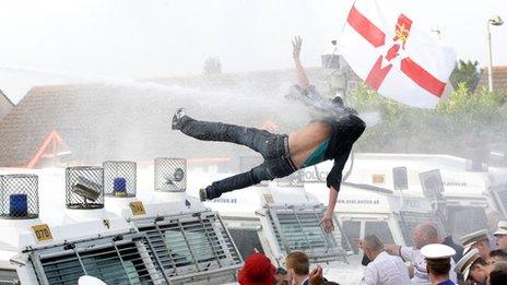 Protester knocked off Land Rover by water cannon