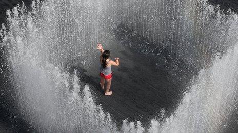 A girl plays in the Appearing Rooms fountain, by Danish artist Jeppe Hein, on London's Southbank