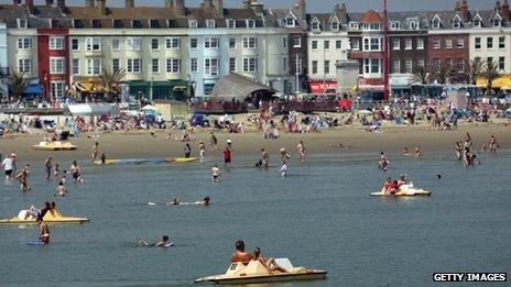 People enjoy the beach on 22 July in Weymouth, England