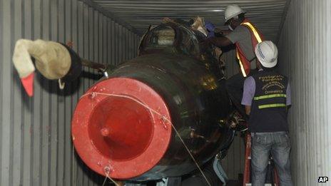 Men inspect military material found aboard the North Korean ship Chong Chon Gang