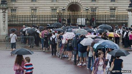 Members of the public and tourists are queuing in the rain outside Buckingham Palace to get a glimpse if the easel