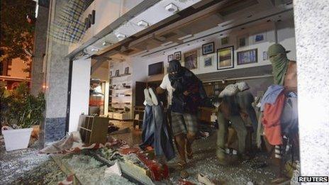 Masked men loot a store during a protest against Rio de Janeiro governor Sergio Cabral in Rio on 17 July 2013