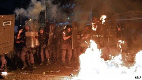 Police shield themselves from Molotov cocktails thrown during a protest in Rio on 22 July 2013