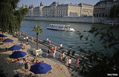 People relax on a temporary urban beach in Paris, near the Pont Neuf bridge, 20 July