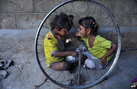 In this photograph taken on October 3, 2011, Indian children eat food at their temporary shelter on the side of the road in Hyderabad.