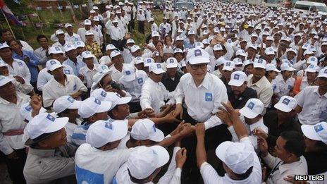 Sam Rainsy (C), president of the Cambodia National Rescue Party (CNRP), is surrounded by his supporters in Kampong Speu province 20 July 2013