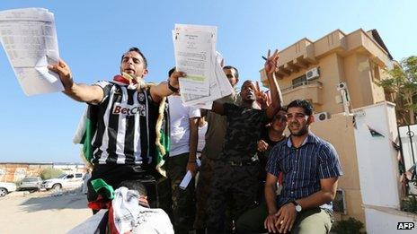 Libyan protesters display documents they have ransacked from the offices of Muslim Brotherhood-backed Party of Justice and Construction, in the Libyan capital Tripoli on 27 July, 2013