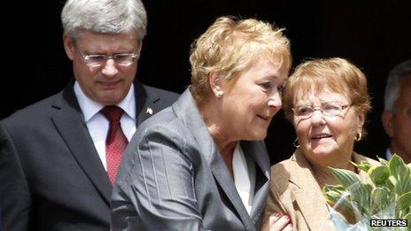 Quebec Premier Pauline Marois (C) comforts a mourner as she and Canadian Prime Minister Stephen Harper (L) walk out of Sainte-Agnes Church following the memorial service to honour the victims of the train derailment in Lac Megantic, Quebec on 27 July, 2013