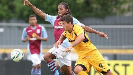 Newport’s Danny Crow battles for the ball with Villa’s Daniel Johnson