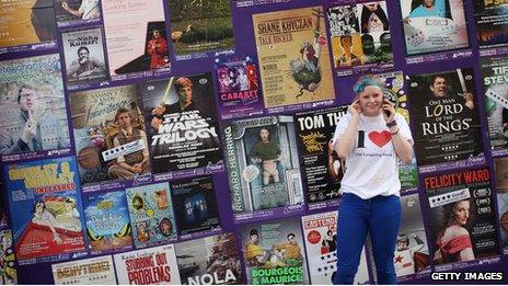 Girl in front of Edinburgh Fringe posters