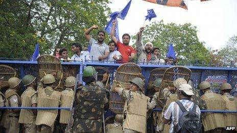 Telangana Joint Action Committee (T-JAC) activists demonstrate as riot police stand behind a barrier during a pro-Telangana protest in Hyderabad on June 14, 2013