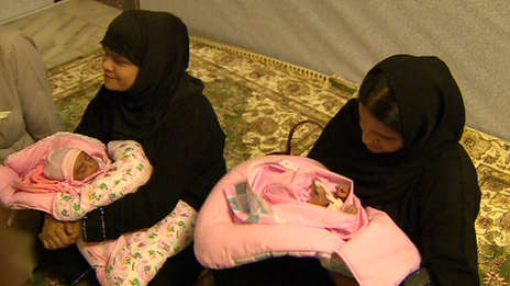 Two women clad in chadors holding babies